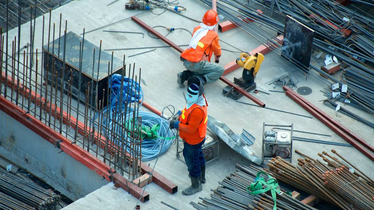 Obreros trabajando en una obra de construcción con equipo de protección