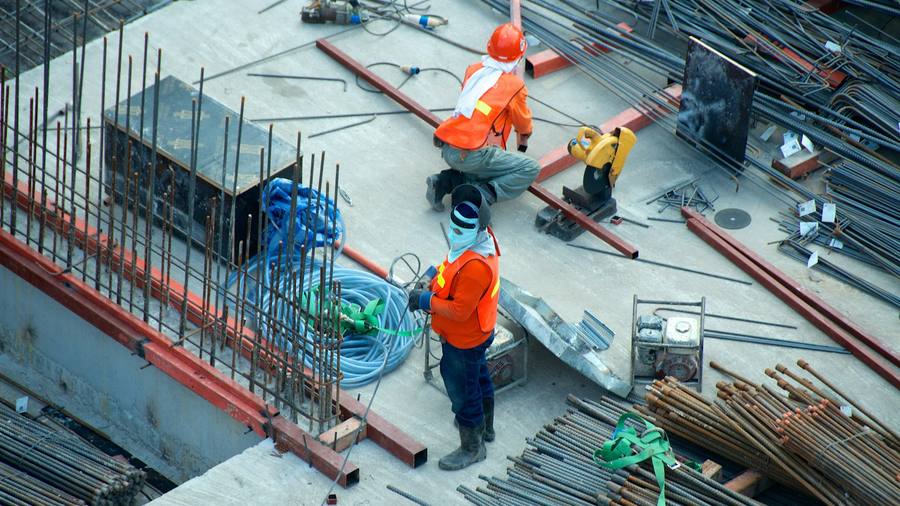 Obreros trabajando en una obra de construcción con equipo de protección