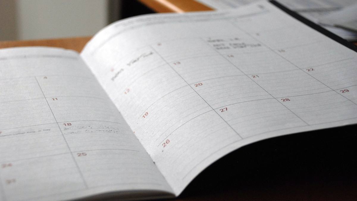 Agenda abierta por la vista mensual sobre una mesa de trabajo