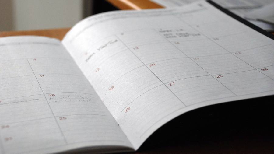 Agenda abierta por la vista mensual sobre una mesa de trabajo